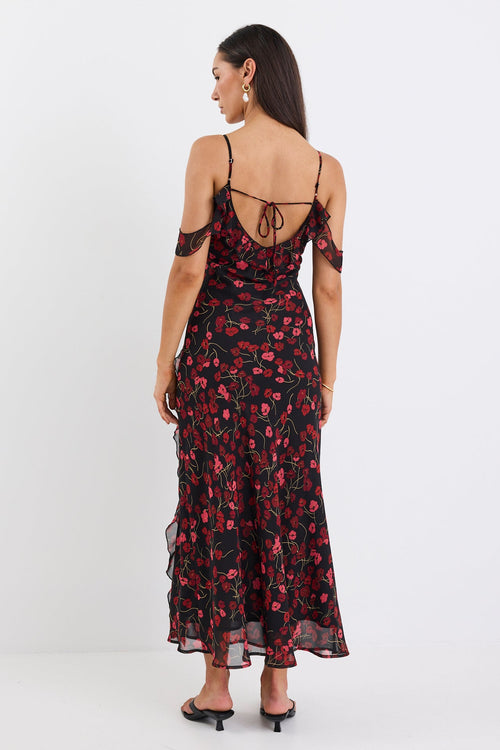 Woman wearing a floral dress with thin straps on a white background