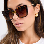 model wears brown tort glasses