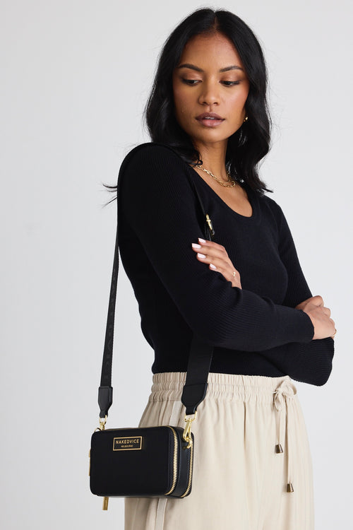 model wears a black crossbody bag