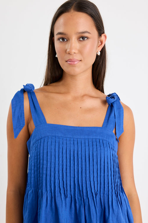Woman wearing a blue ramie mini dress with bow straps