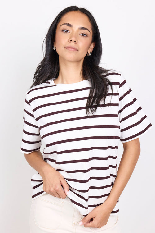 Woman wearing a black and white striped shirt against a white background