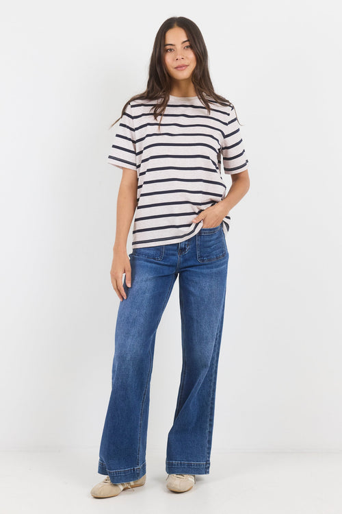 Woman wearing a striped shirt and blue jeans on a white background