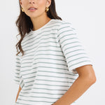 model wears a khaki and white stripe tee with light blue jeans