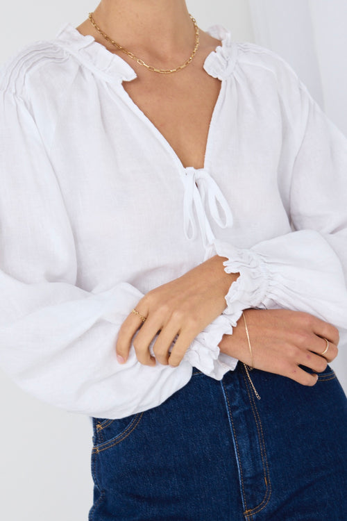 model wears white long sleeve top and blue denim jeans