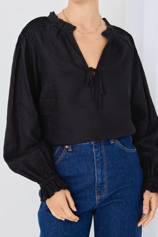 model wears a black linen long sleeve top
