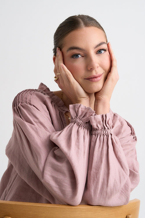 model wears pink long sleeve linen top