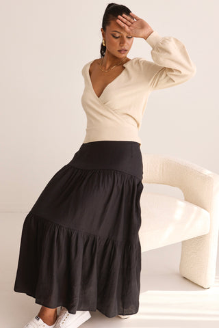 model wears a black linen midi skirt