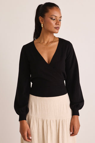 model wears a black wrap knit