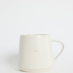 Cream-coloured ceramic mug with the word ‘Bliss’ embossed on the front, photographed on a white background