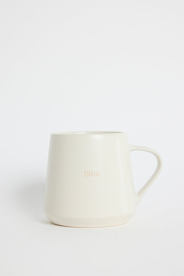 Cream-coloured ceramic mug with the word ‘Bliss’ embossed on the front, photographed on a white background