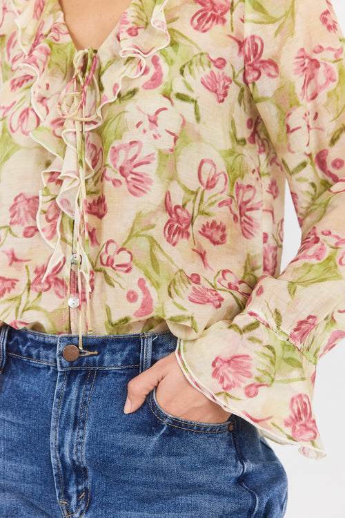 Floral blouse with long sleeves and a person wearing it, paired with blue jeans.