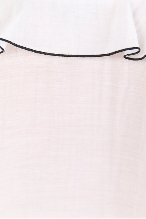 Close-up of a white top with black trim