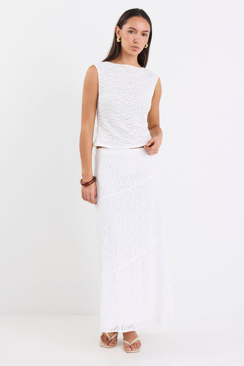 Woman wearing a lace top and skirt in white