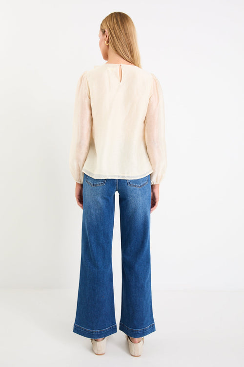 cream frill top and blue jeans