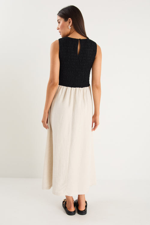 Woman wearing a black top and white skirt on a white background