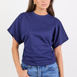 Woman wearing a blue tee and jeans on a white background