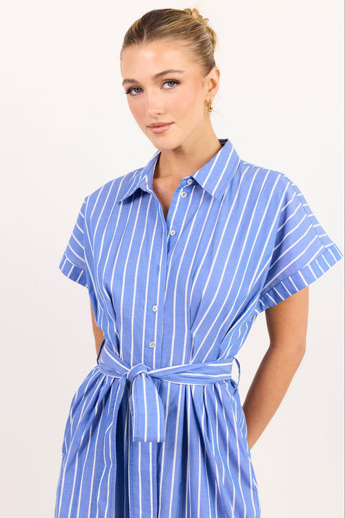 A woman modeling a blue and white vertically striped short-sleeve shirt dress with a matching tie belt, set against a plain light background.