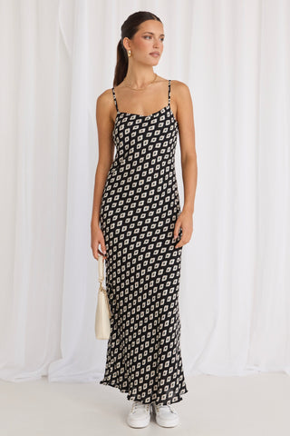 model wears a black print bias maxi dress