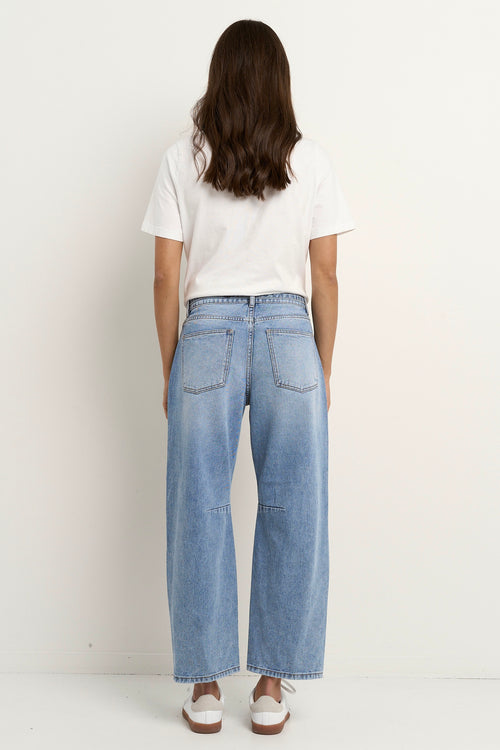 model wears a light blue barrel leg jean with a white t-shirt