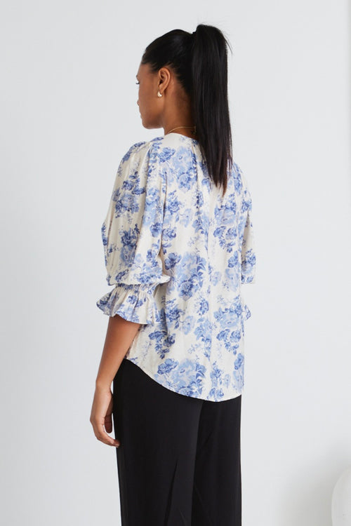 model wears blue floral top