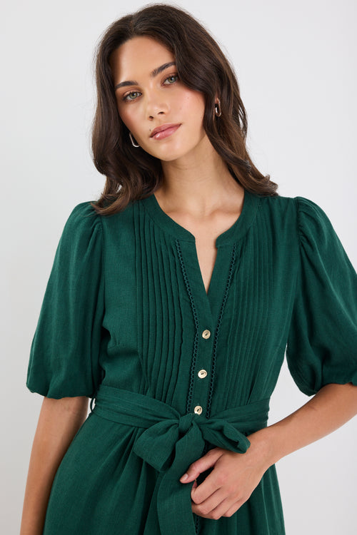 Woman wearing a green dress with a plain background