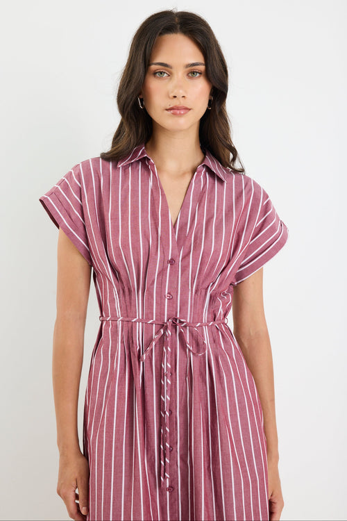 Woman wearing a striped dress against a plain background