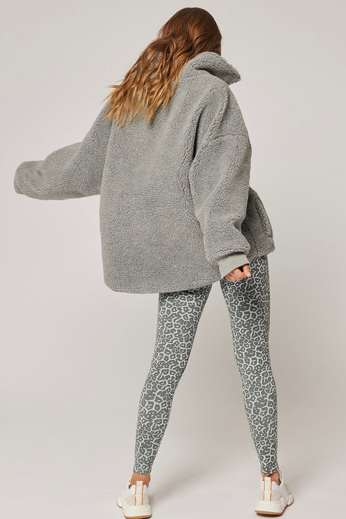 model wears a grey jumper