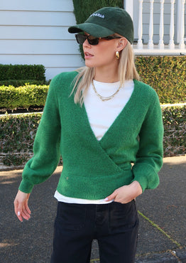 model wears a green knit