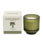 A coconut-scented scented candle by Willow & Mae in a ribbed olive green glass jar, shown next to its white packaging box with a green palm tree logo.