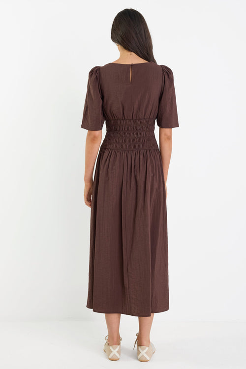 Woman wearing a brown dress on a white background