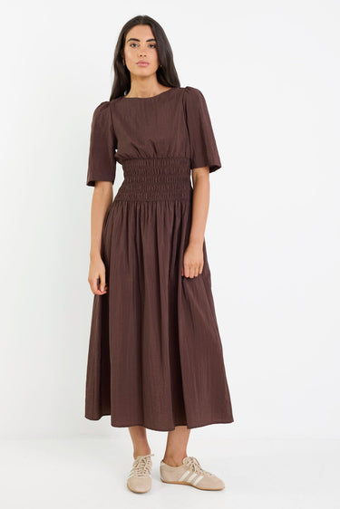 Woman wearing a brown dress on a white background