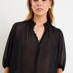 Woman wearing a black white polka dot top