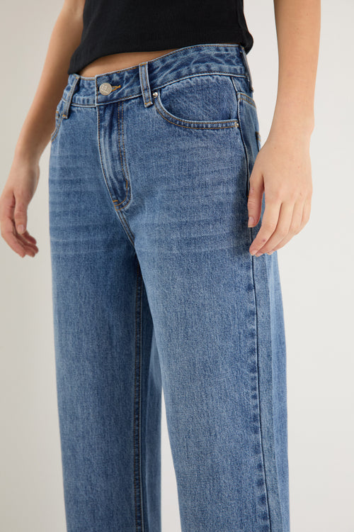 model wears a mid rise blue jean with a black tank top 
col_pattern