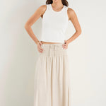 model wears a natural linen maxi skirt with a white tank top