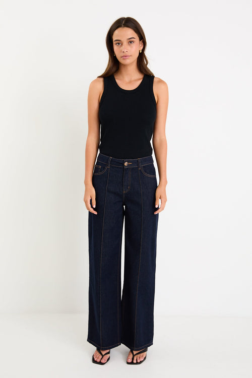 Woman wearing dark denim jean and black singlet
