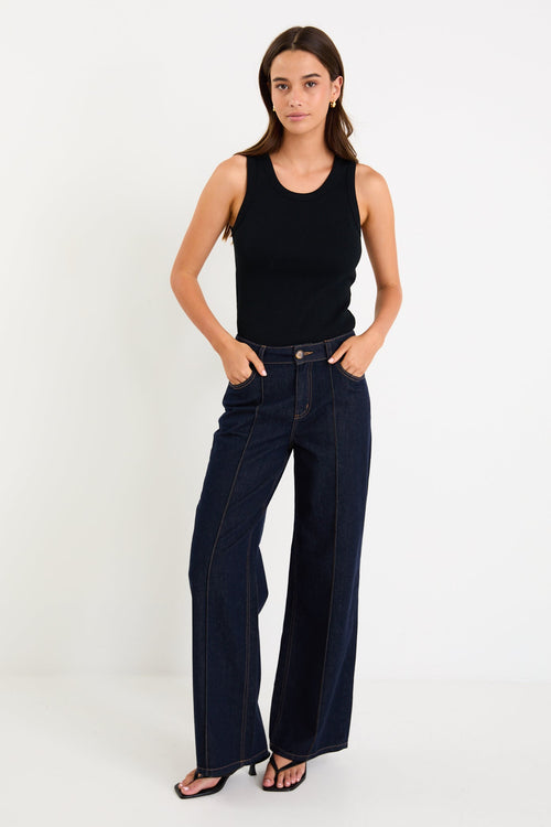 Woman wearing dark denim jean and black singlet