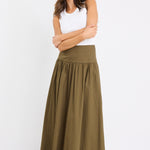 model wears a khaki maxi skirt with a white tank top