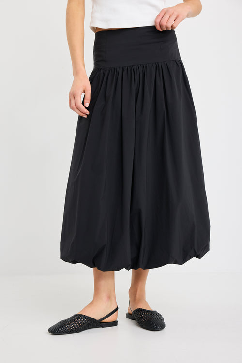 Person wearing a black skirt on a white background
