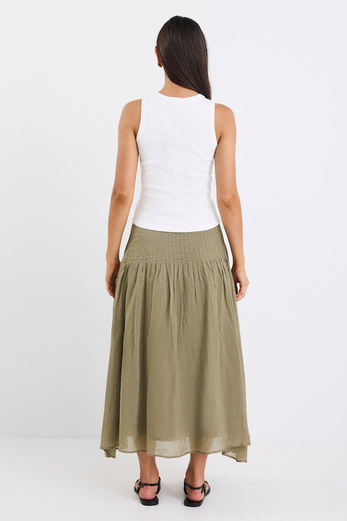 Woman wearing a white top and green skirt on a white background