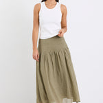 model wearing khaki linen skirt and white top