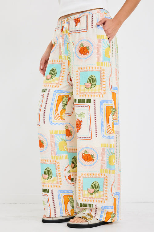 model wears a multi coloured fruit print draw string pant