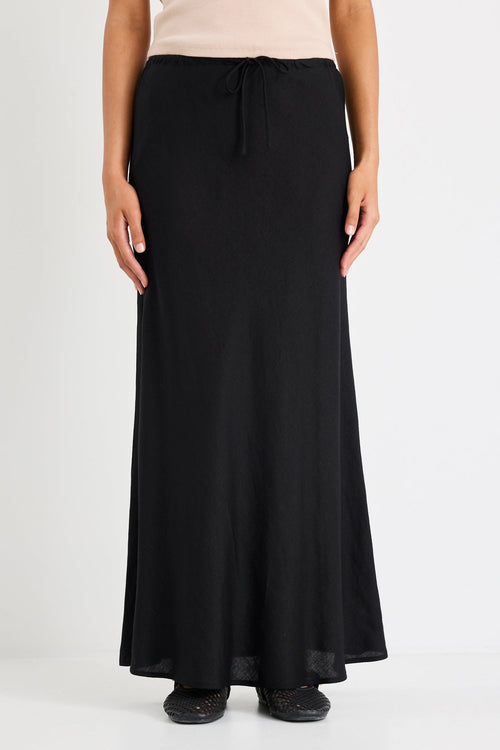 Woman wearing black skirt and taupe tank