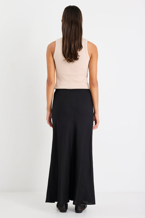 Woman wearing black skirt and taupe tank