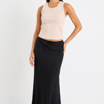 Woman wearing black skirt and taupe tank