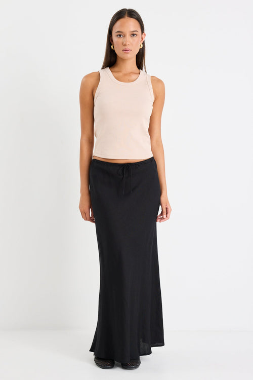 Woman wearing black skirt and taupe tank