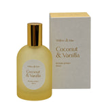 A bottle of Willow & Mae Coconut & Vanilla room spray next to its packaging box, both in a warm yellow and gold color scheme, set against a plain white background.