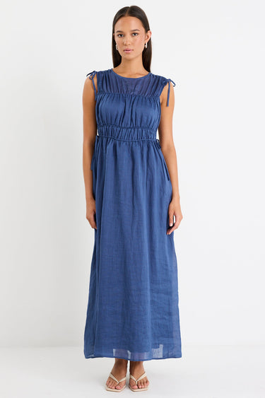 Woman wearing a navy ruched maxi dress