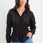 Woman wearing a black blouse and blue jeans on a white background