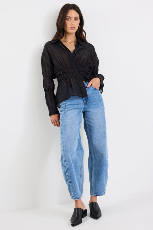 Woman wearing a black shirt and blue jeans on a white background