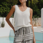 Woman wears a white natural knit top and khaki pants